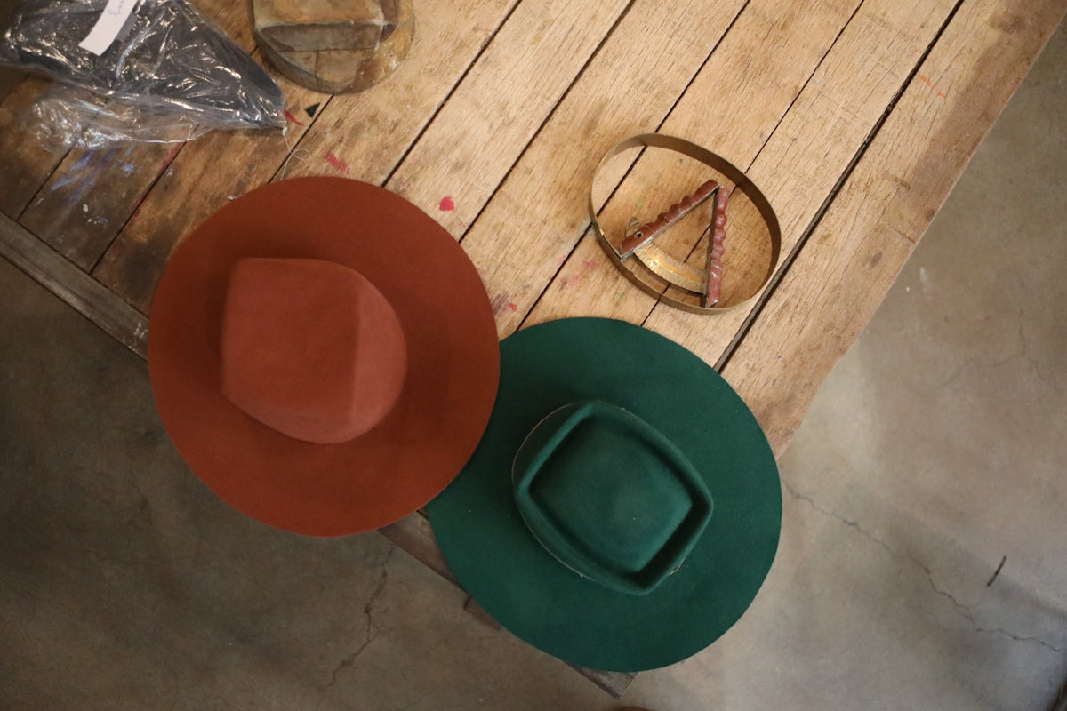 red cowboy hat on brown wooden table
