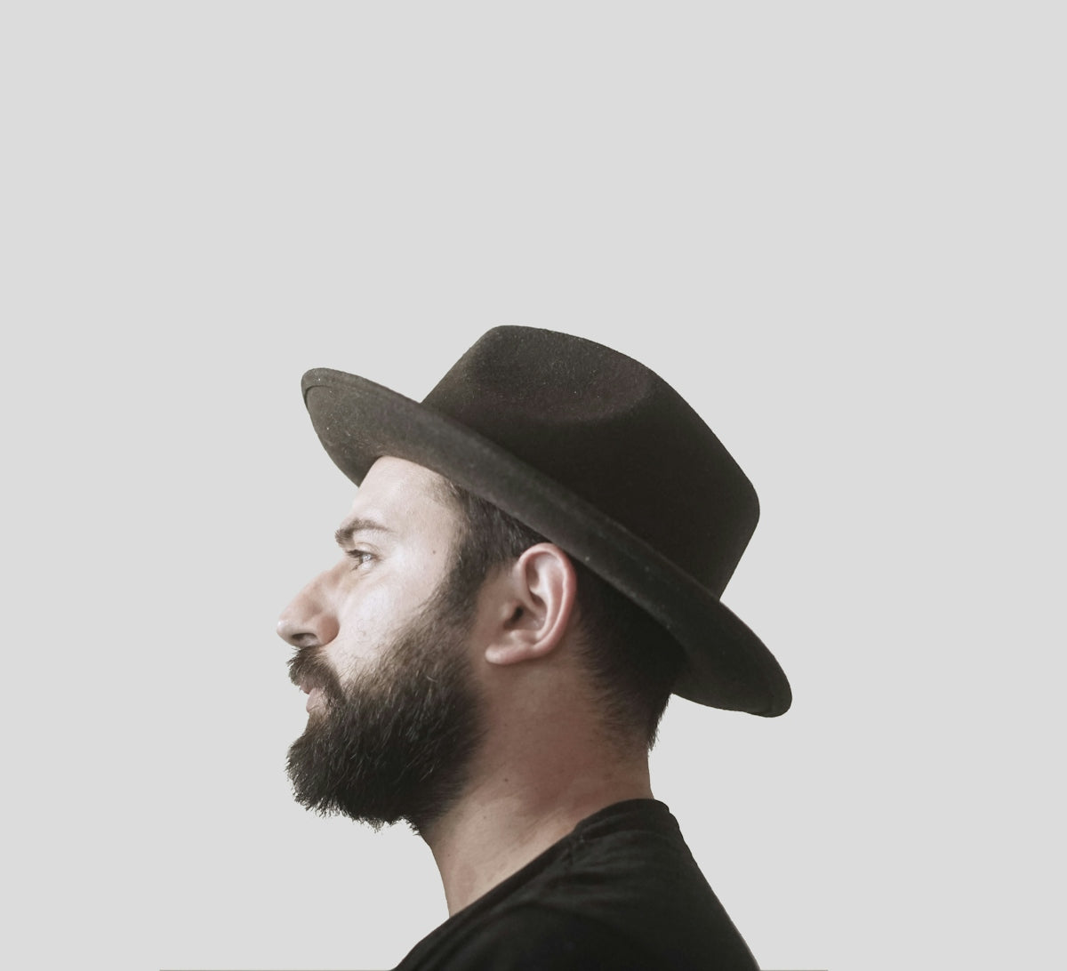 a man with a beard wearing a black hat