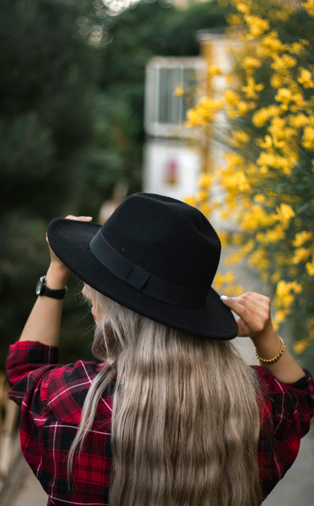 woman in black fedora hat and red plaid shirt