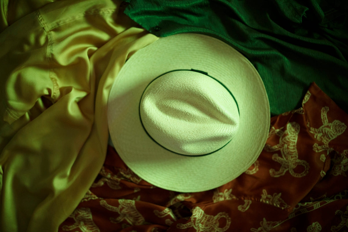 white fedora hat on green textile