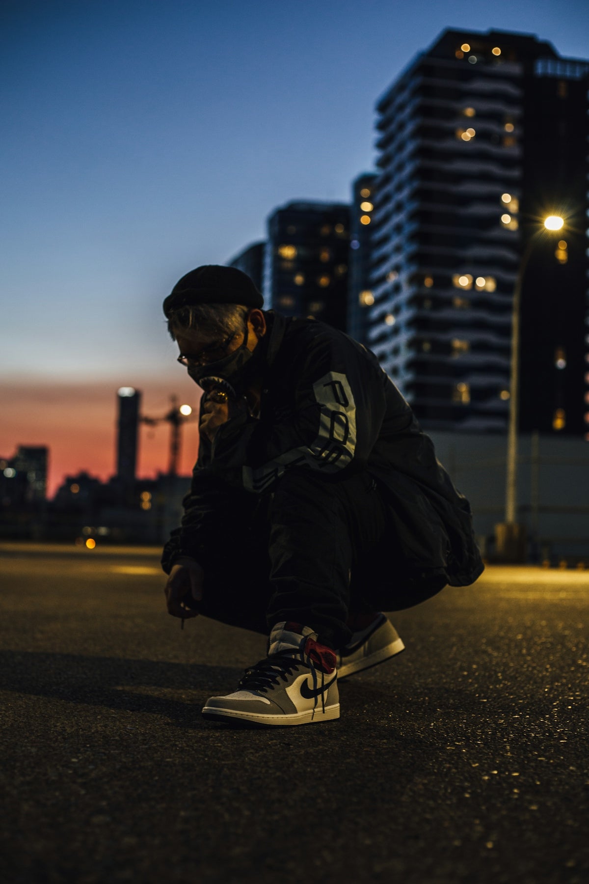 man in black jacket and black pants sitting on the ground