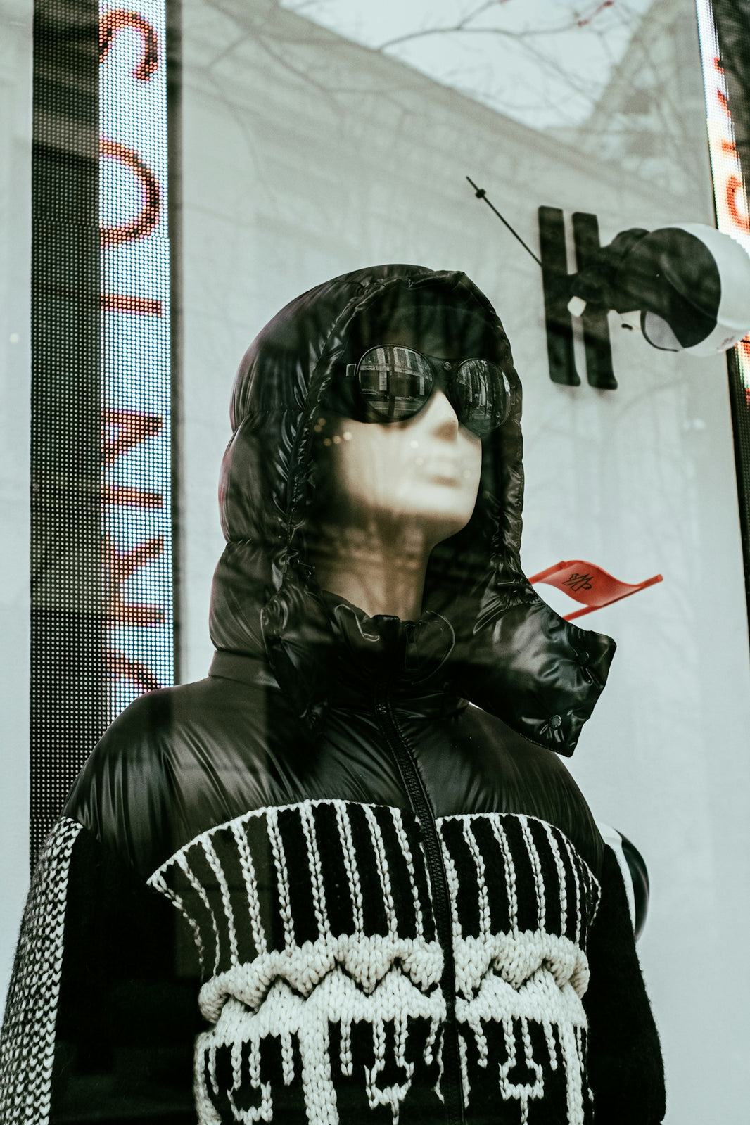 a mannequin wearing a black jacket with a red bird on it
