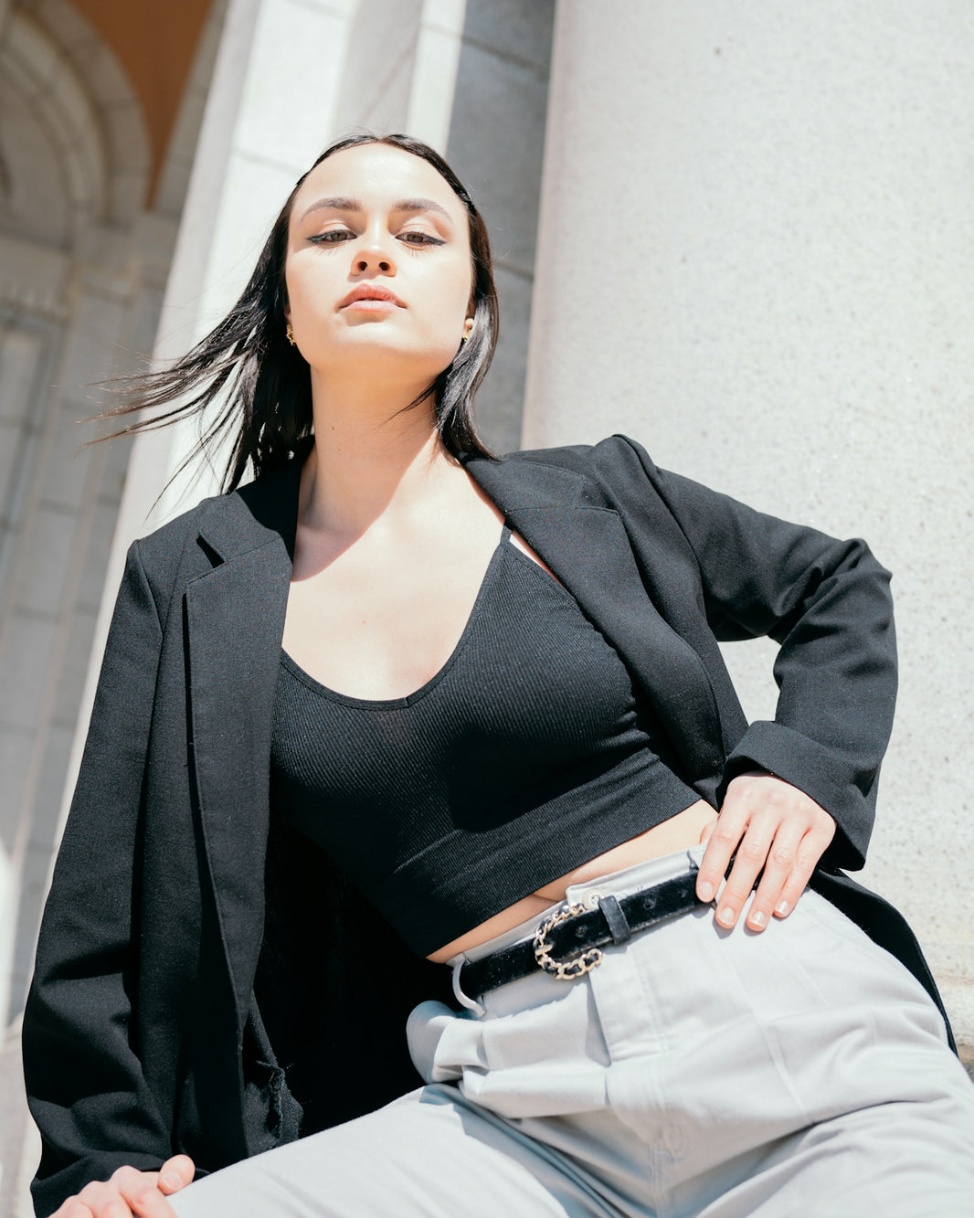 a woman in a black top and grey pants