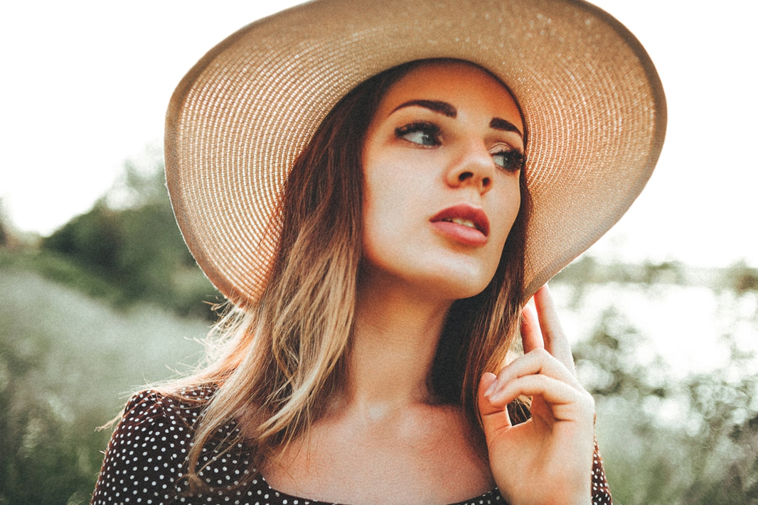 a woman in a hat is posing for a picture