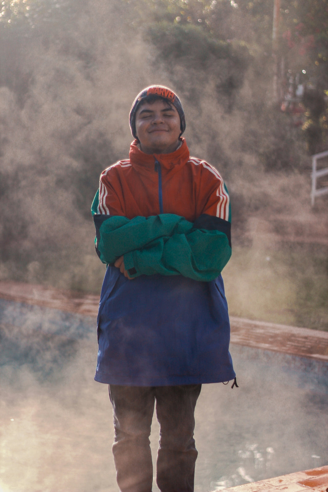 a boy wearing a blue jacket and a hat with a scarf around his neck