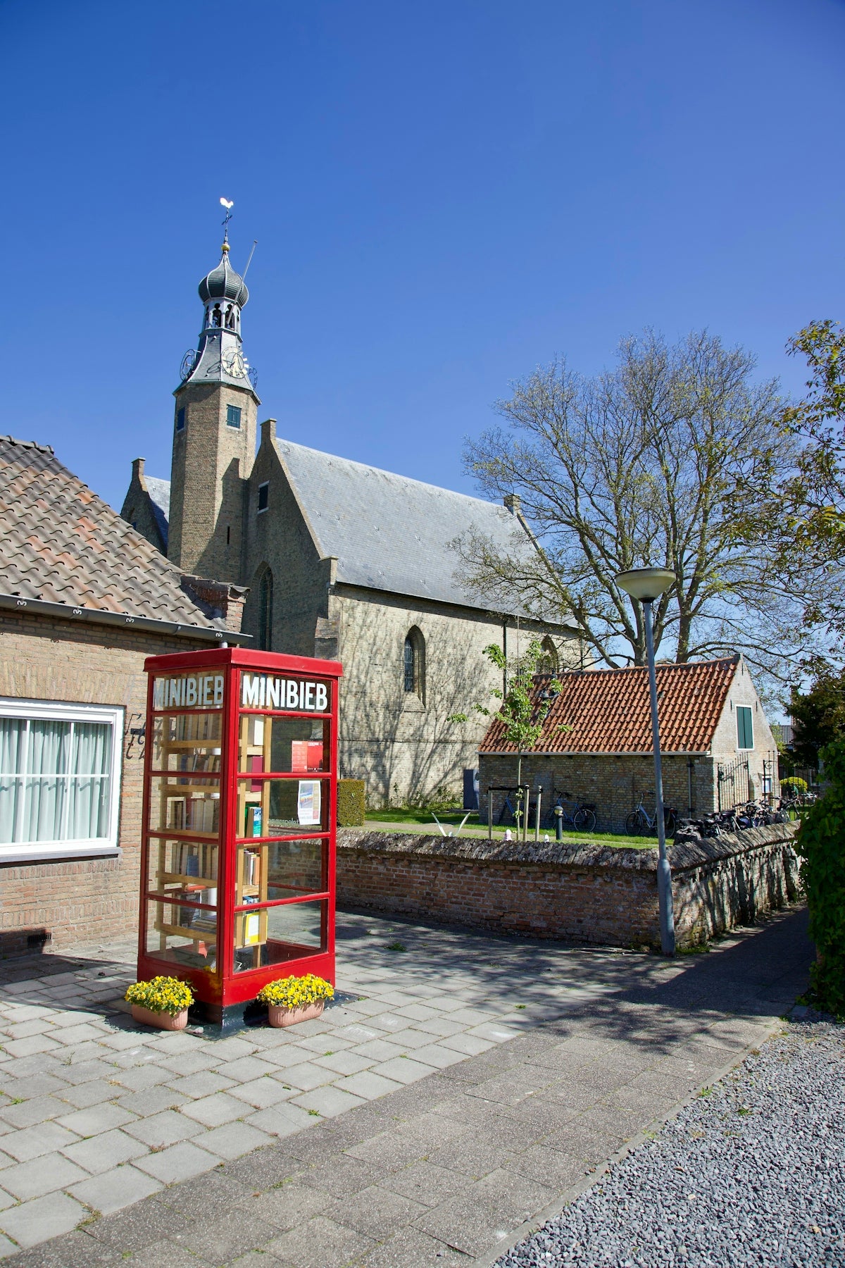a red phone booth sitting on the side of a road