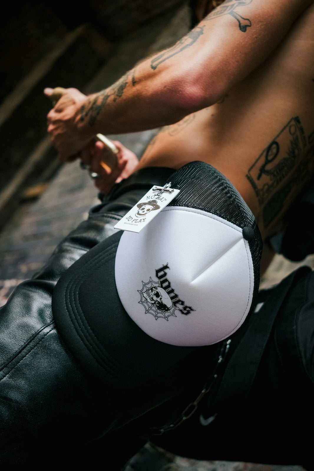 a shirtless man sitting on the ground wearing a white and black boxing glove