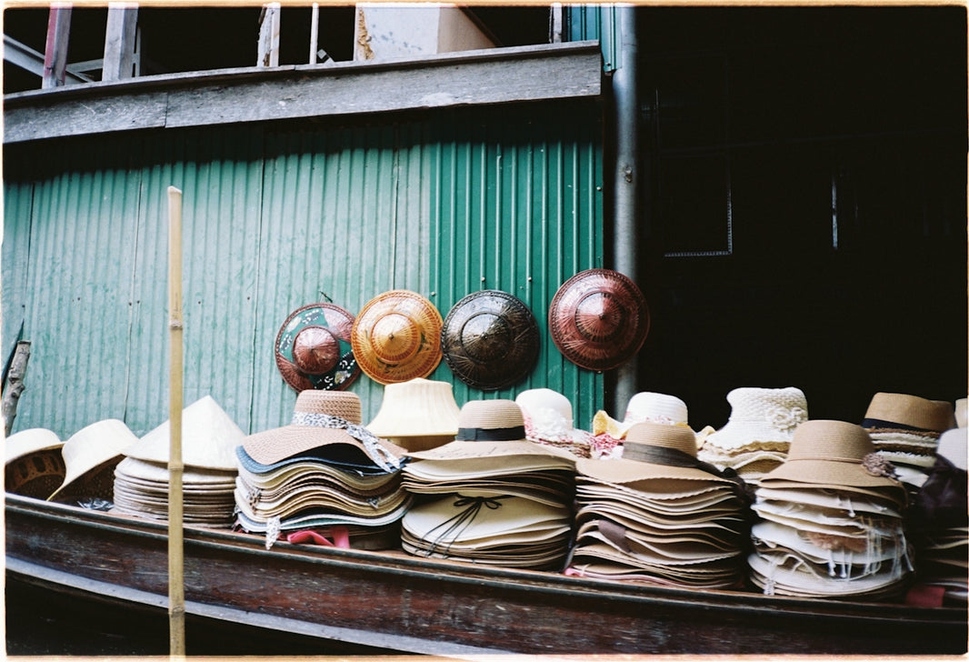 a boat filled with lots of hats next to a building