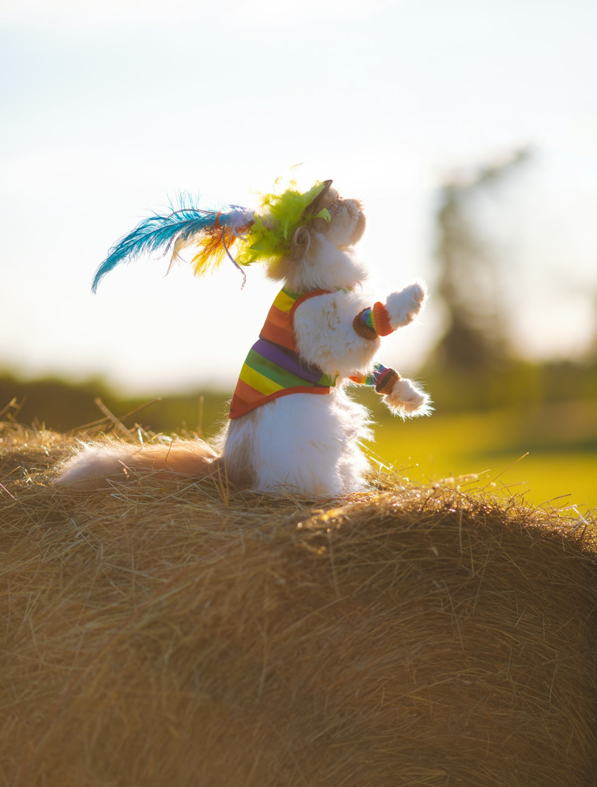 a stuffed animal is sitting on a bale of hay