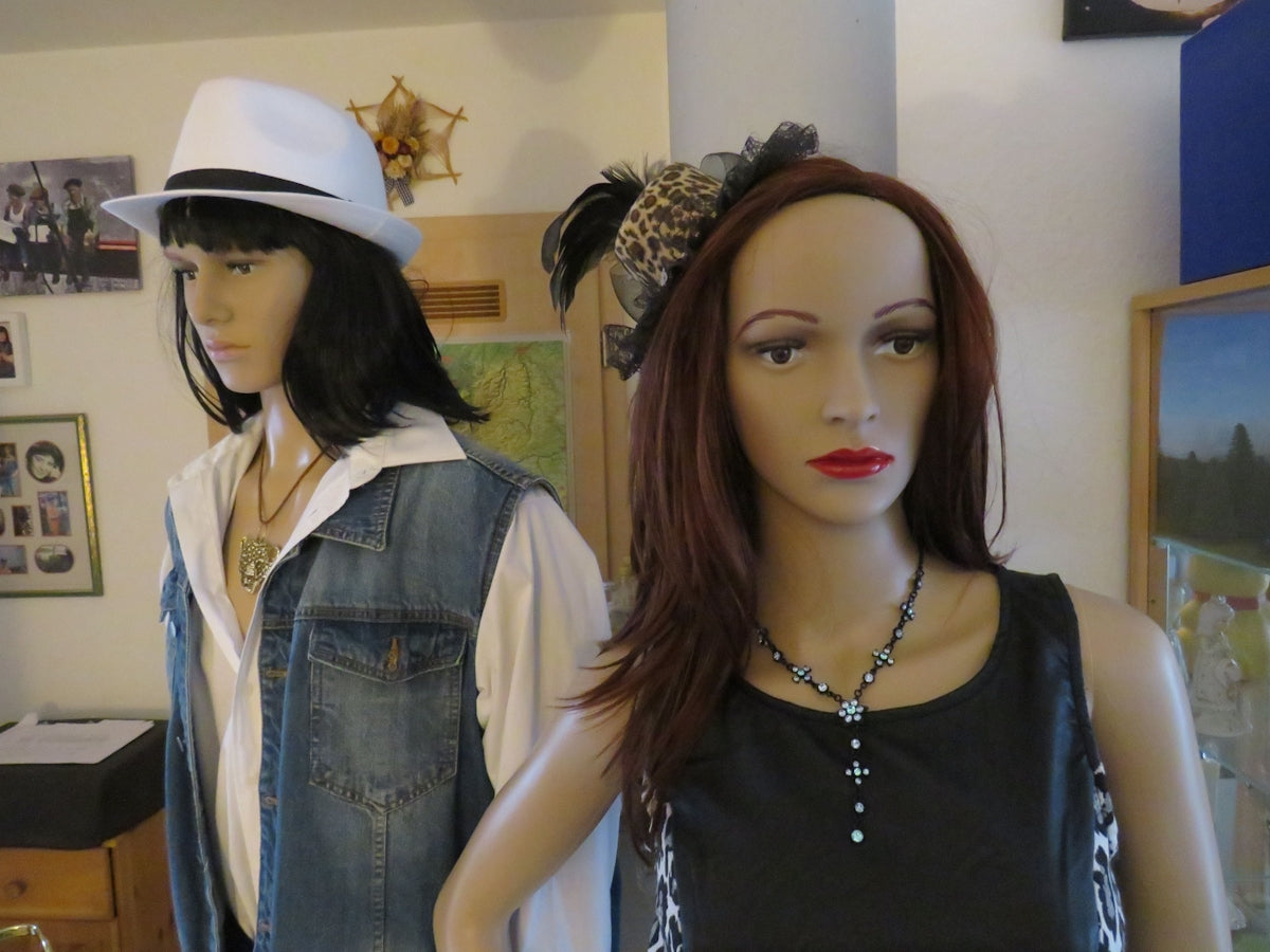 two mannequins wearing hats in a room