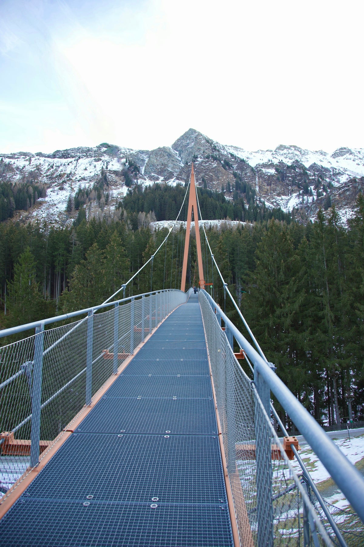 a suspension bridge with a mountain in the background