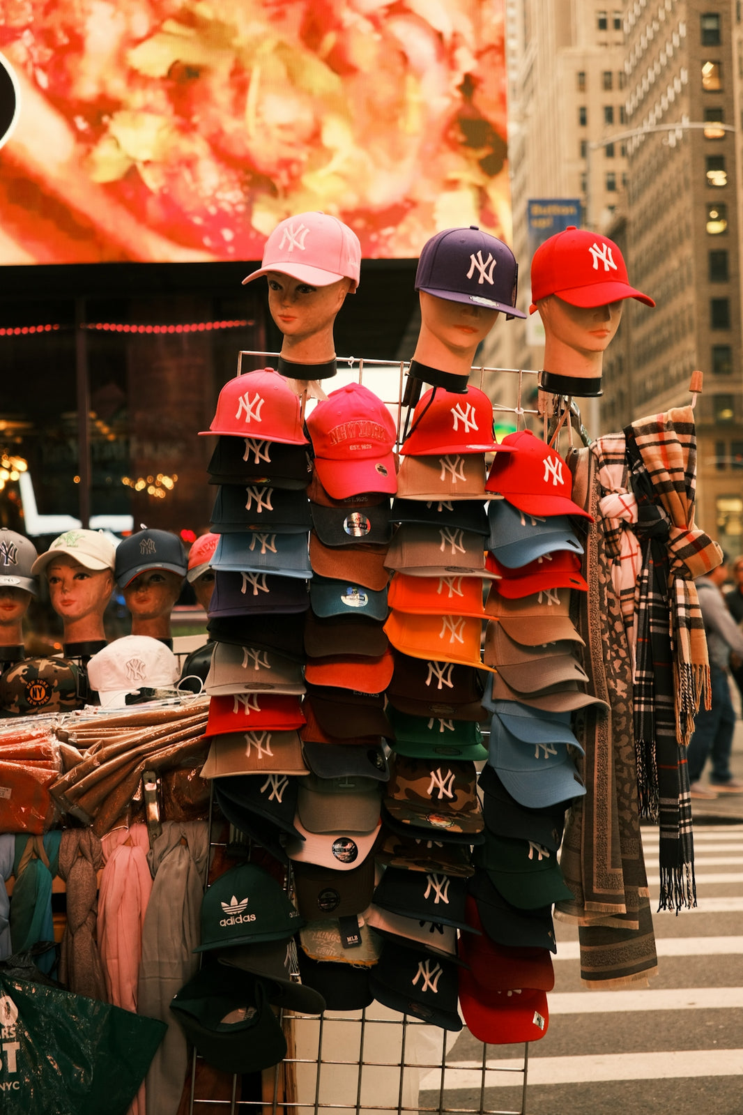 a display of hats and scarves on a street corner
