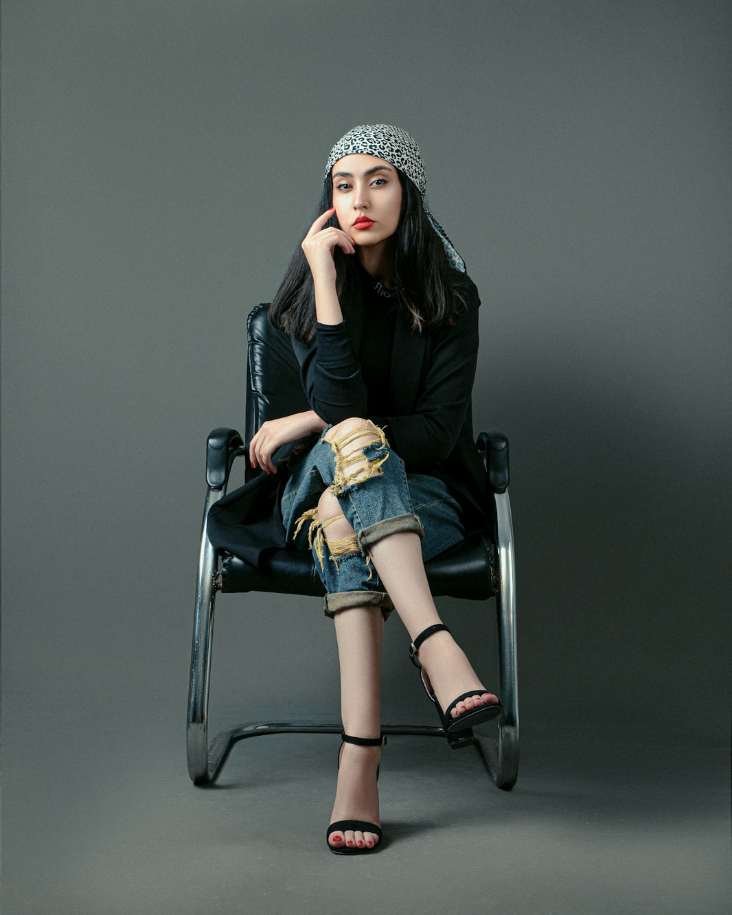 a woman sitting in a chair with her hand on her chin