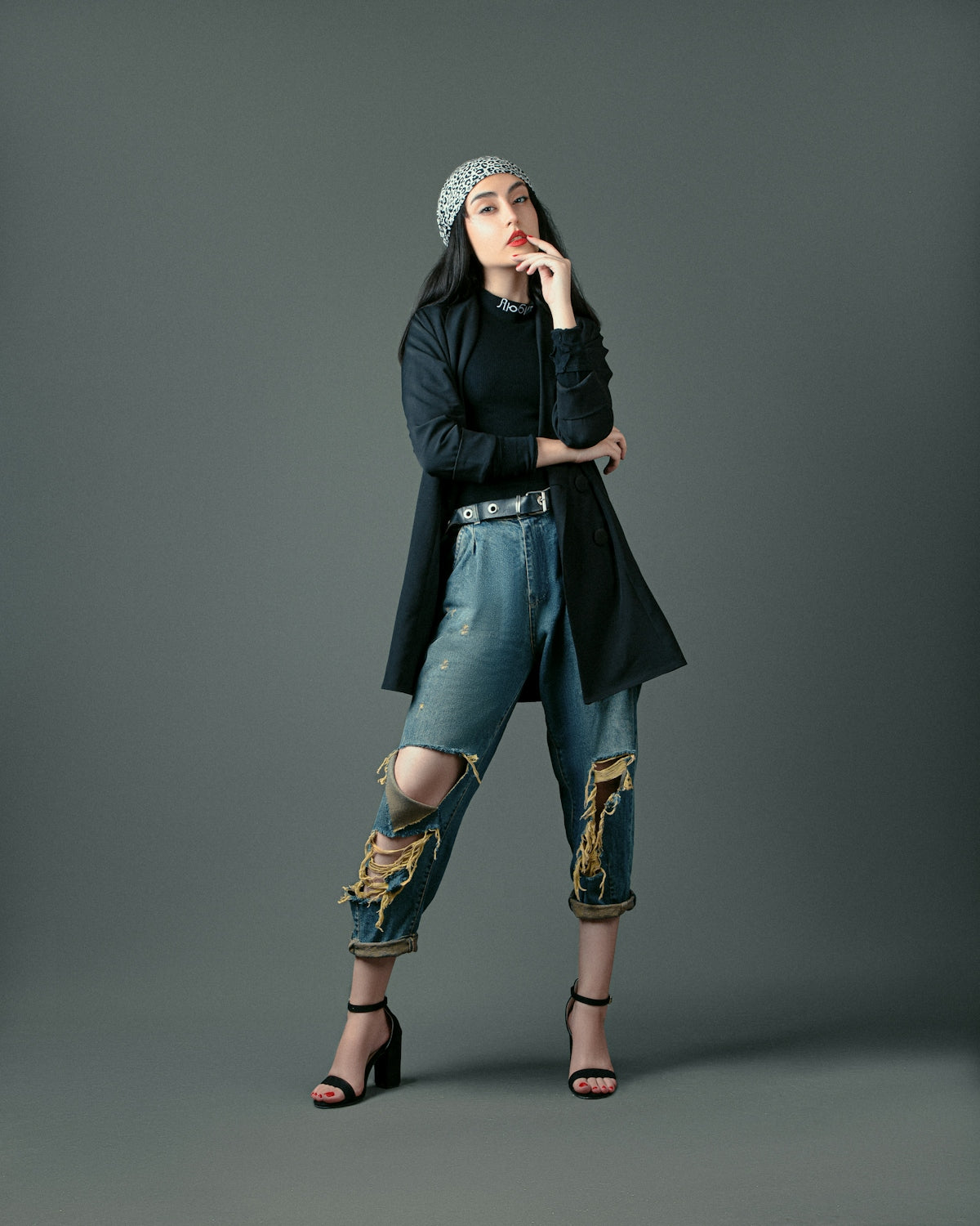 a woman in a black top and jeans posing for a picture