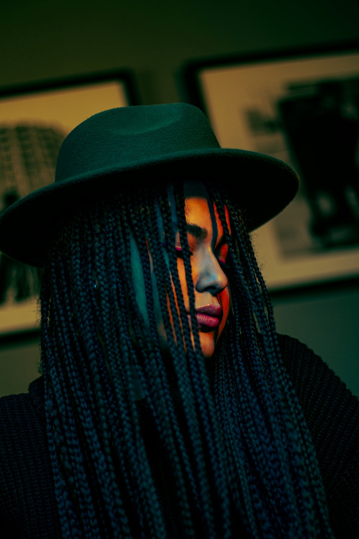a woman wearing a green hat and long braids