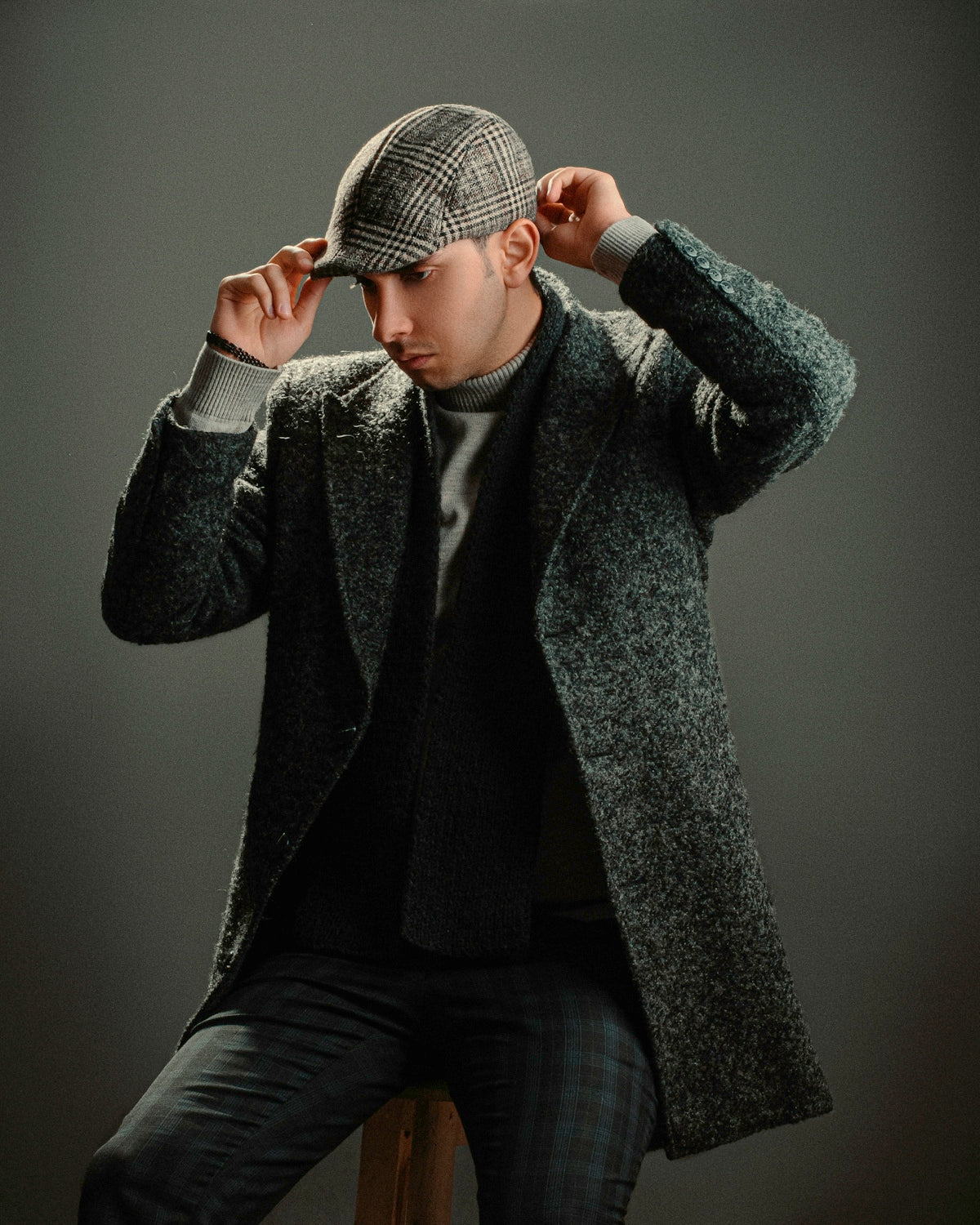 a man sitting on top of a chair wearing a hat