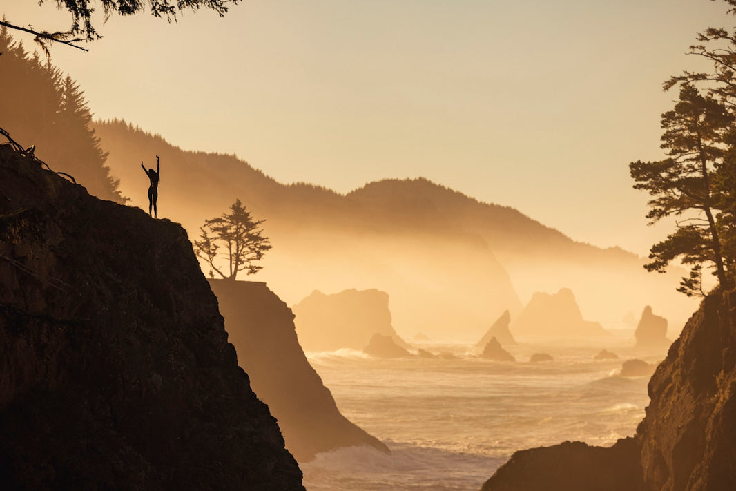 a person standing on a cliff overlooking the ocean