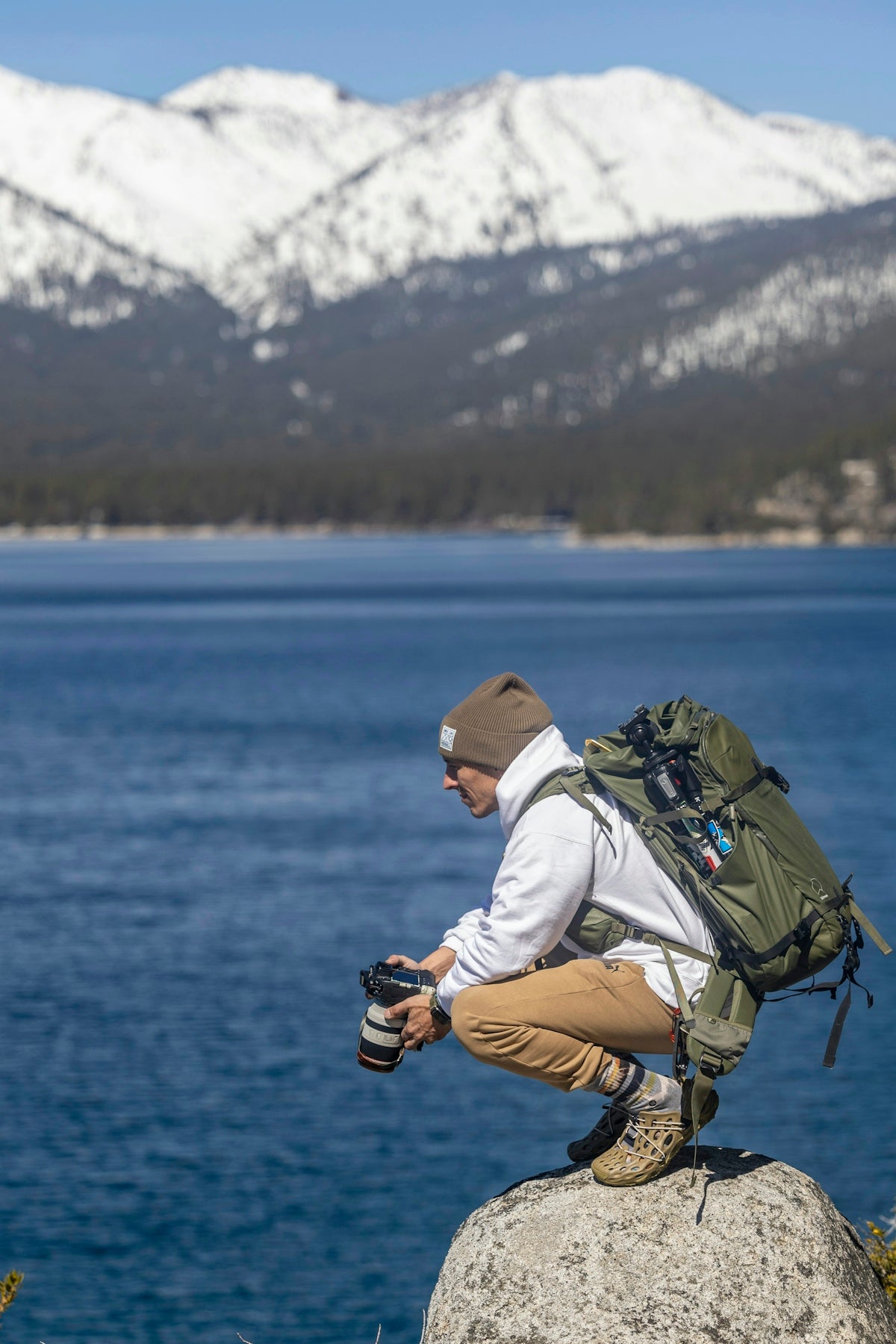 a man sitting on a rock with a camera