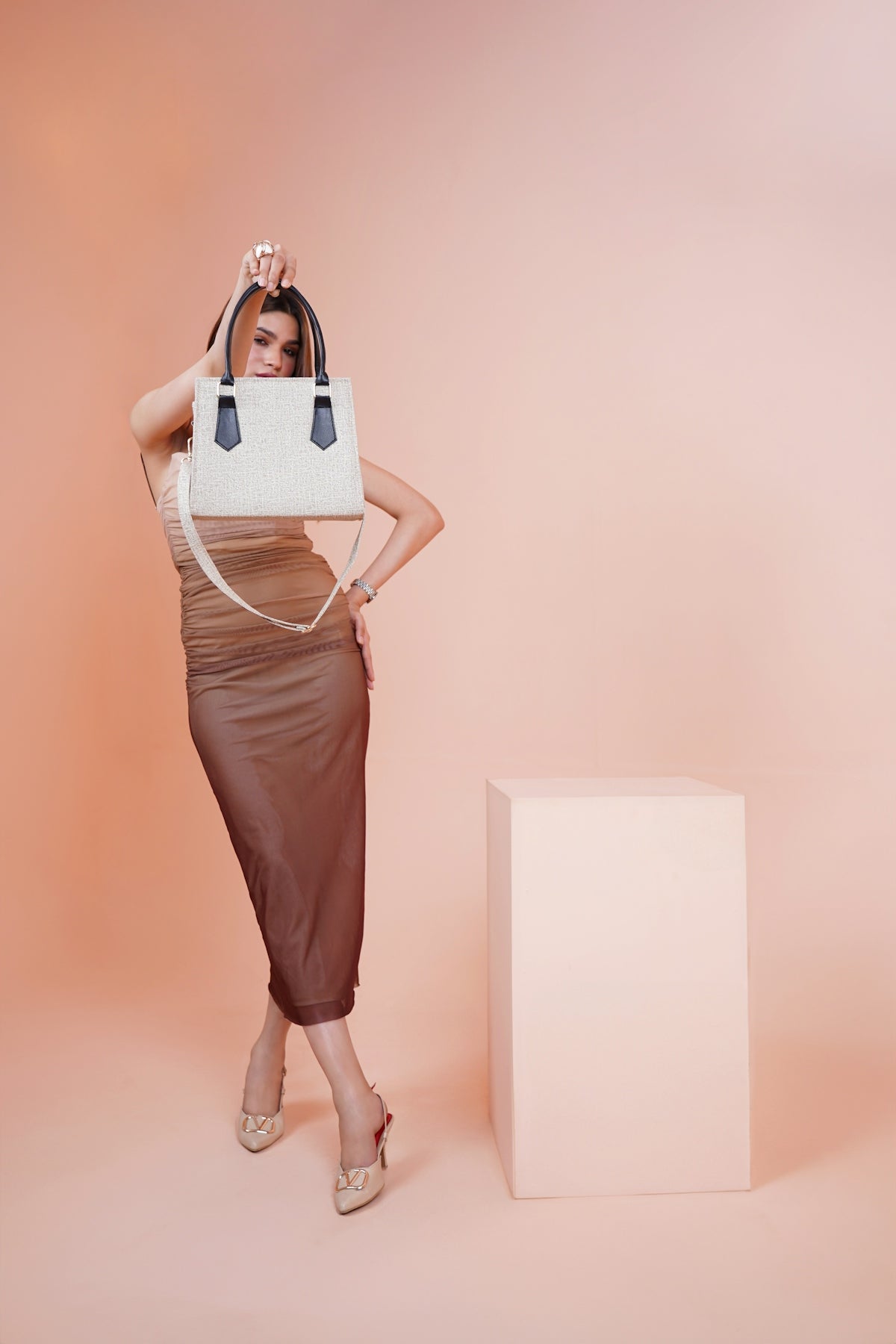 a woman in a brown dress holding a white purse