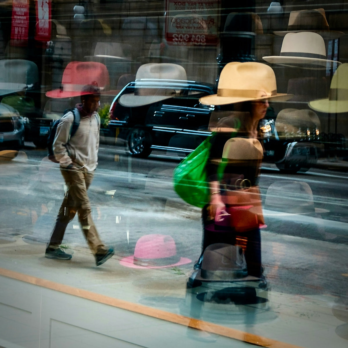 A man and a woman walking past a store window