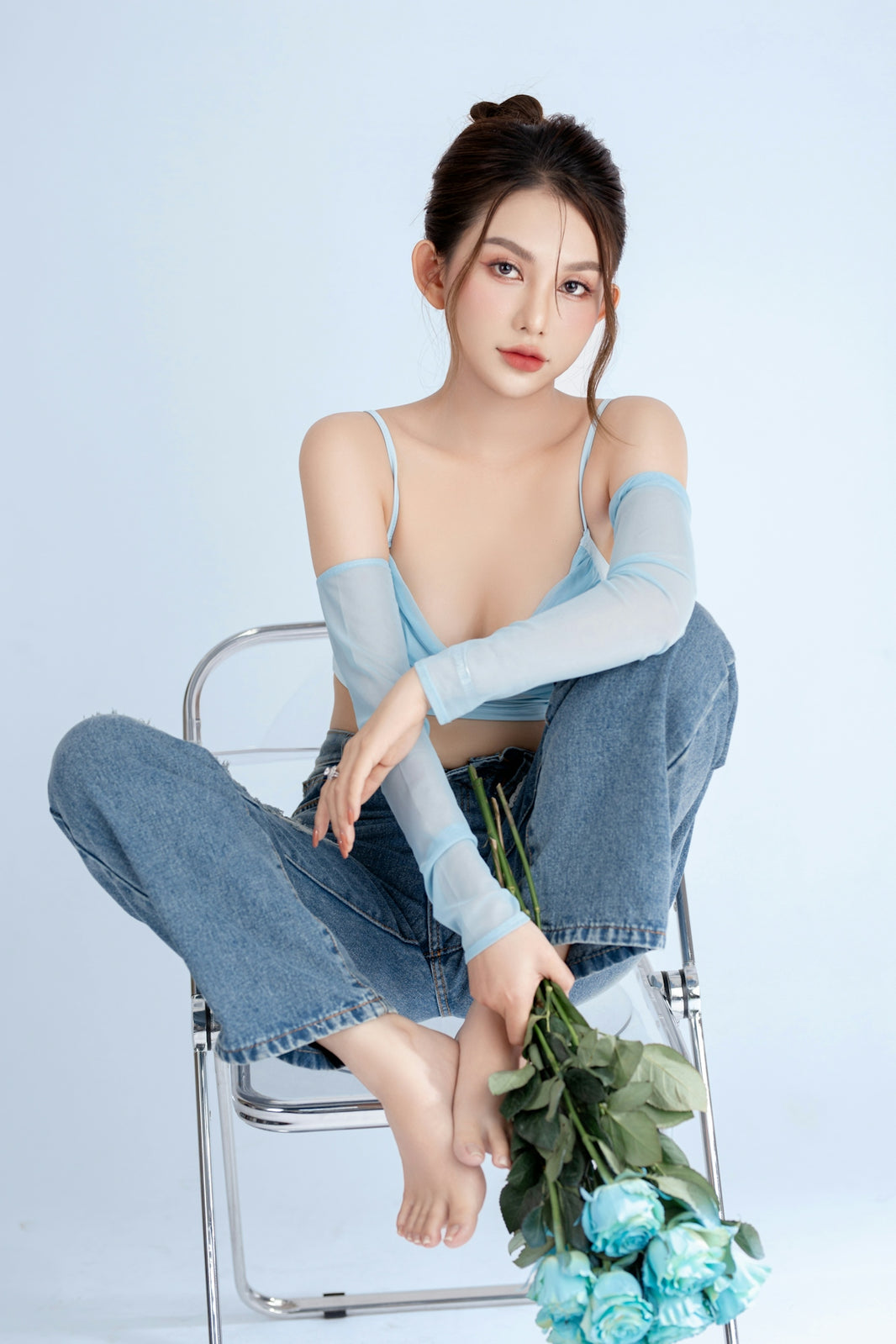 A woman sitting on a chair holding a bouquet of flowers