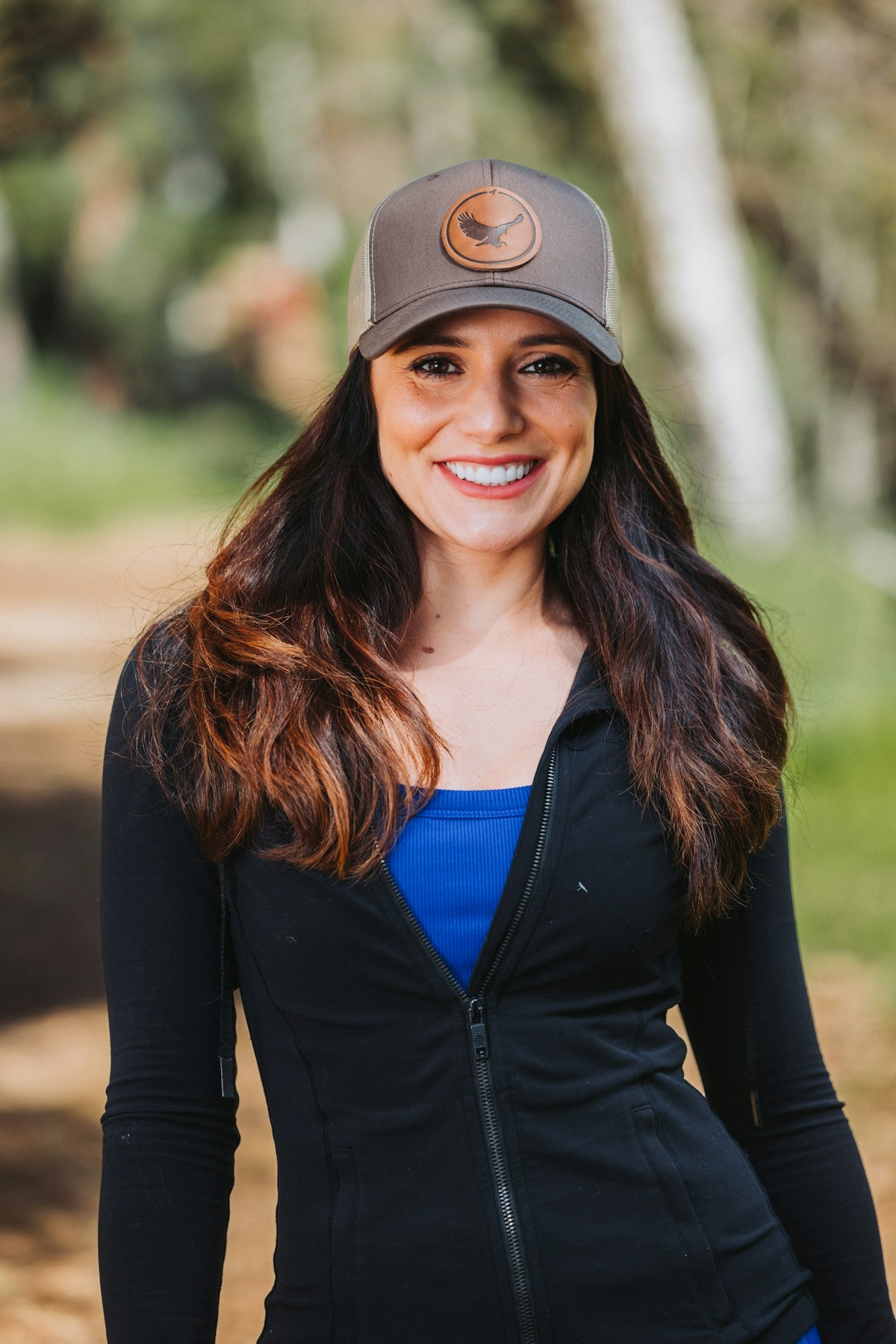 A woman wearing a hat and smiling for a picture