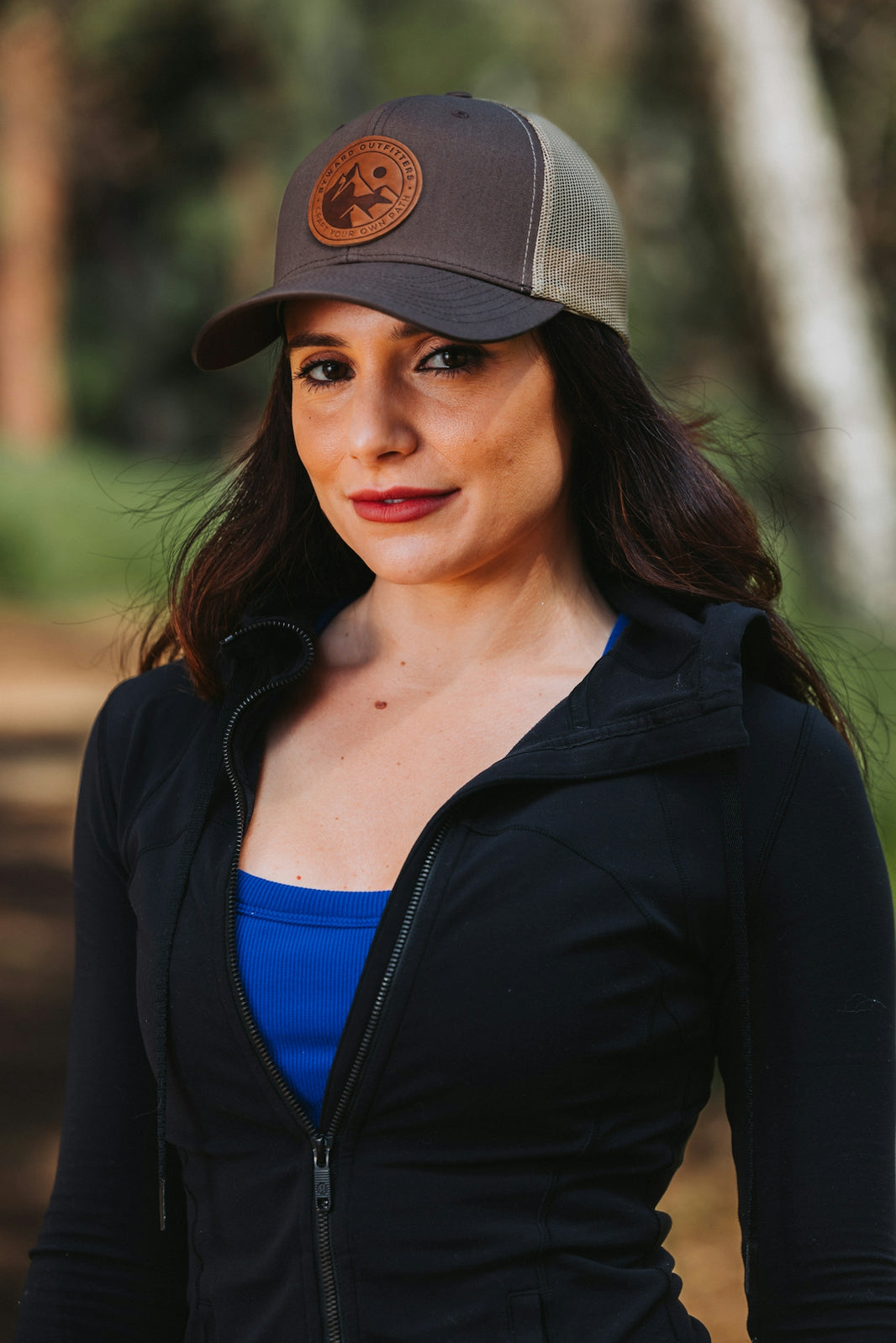 A woman wearing a black jacket and a brown hat