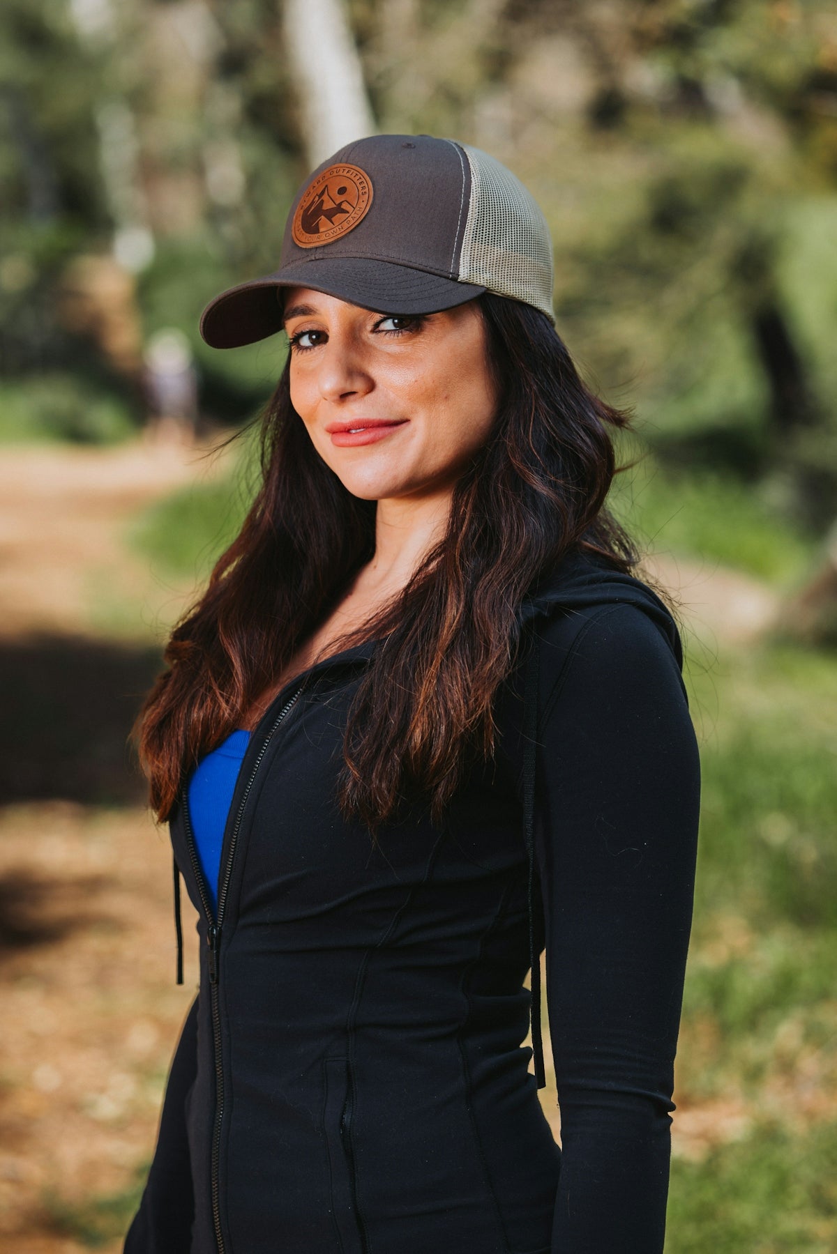 A woman wearing a hat standing in a park