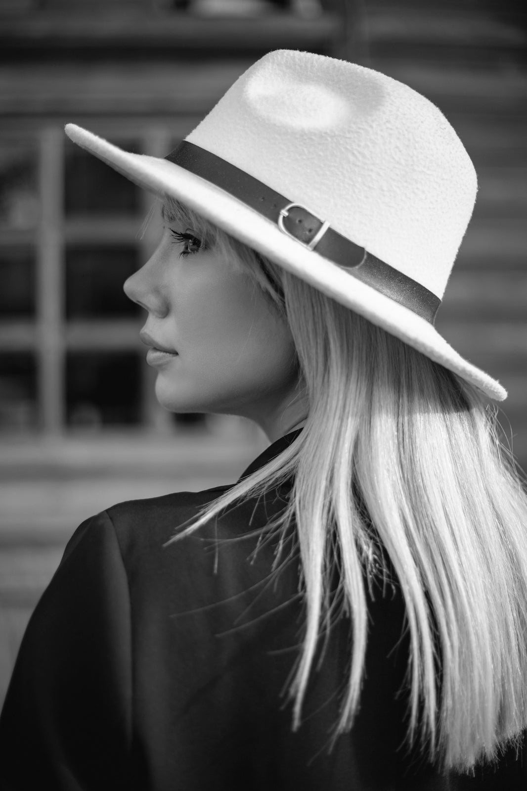 A woman wearing a white hat with a black band