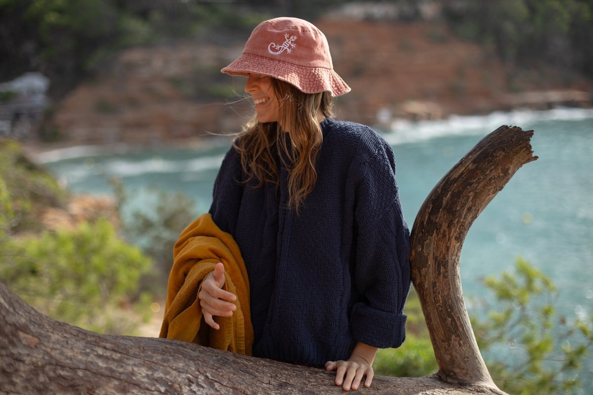 A woman in a pink hat sitting on a tree branch