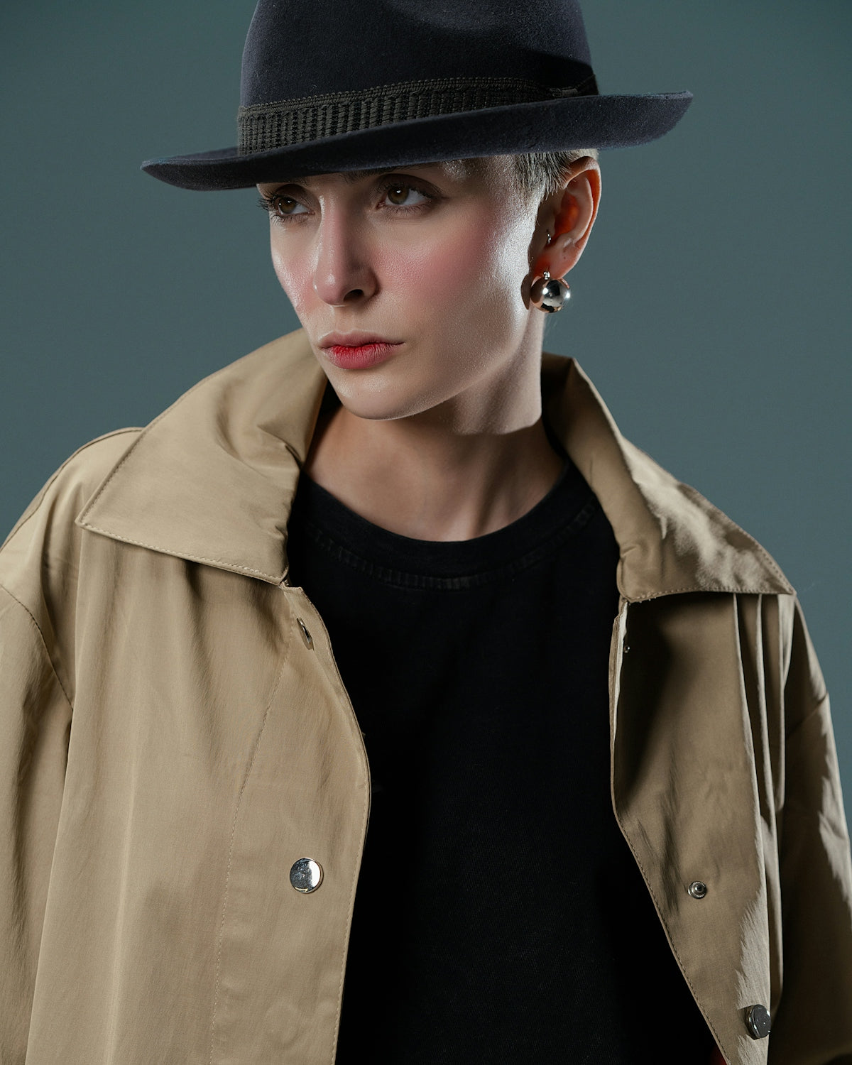 A woman wearing a trench coat and a hat
