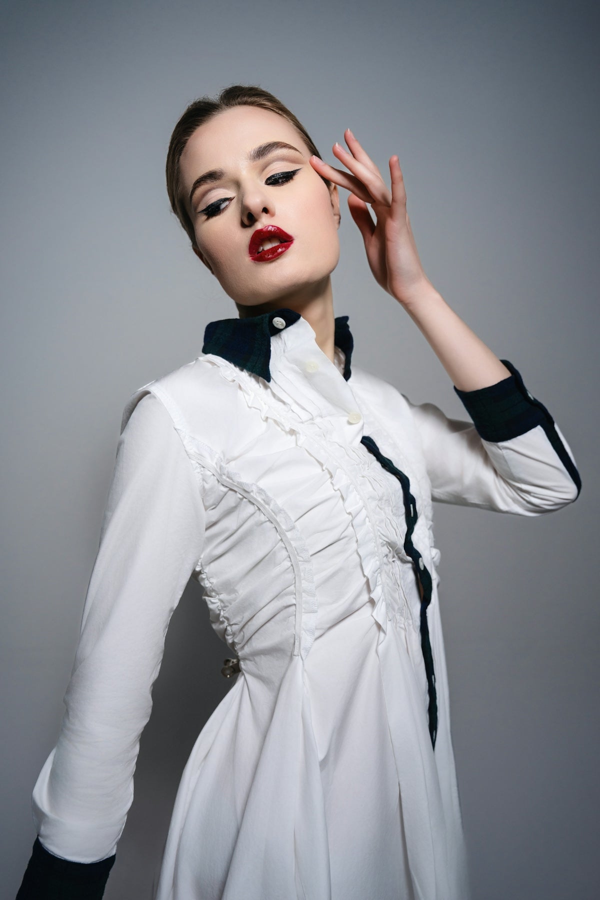 A woman wearing a white dress and black gloves