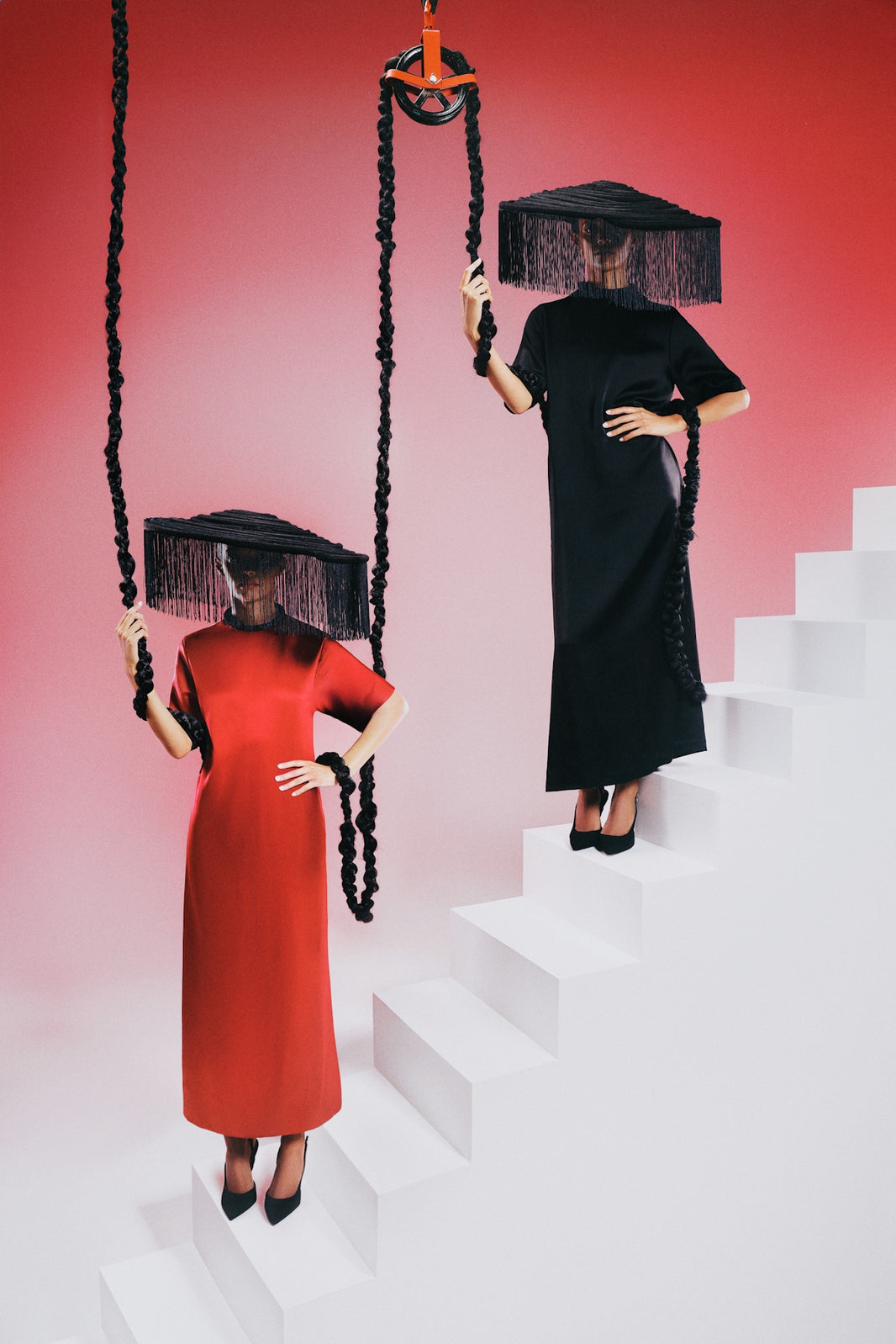 Fashion models pose with a pulley and stairs.