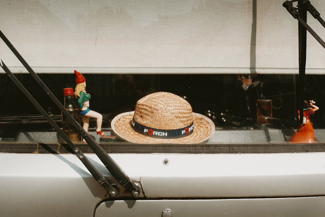 Hats and figurines sit inside a vehicle.