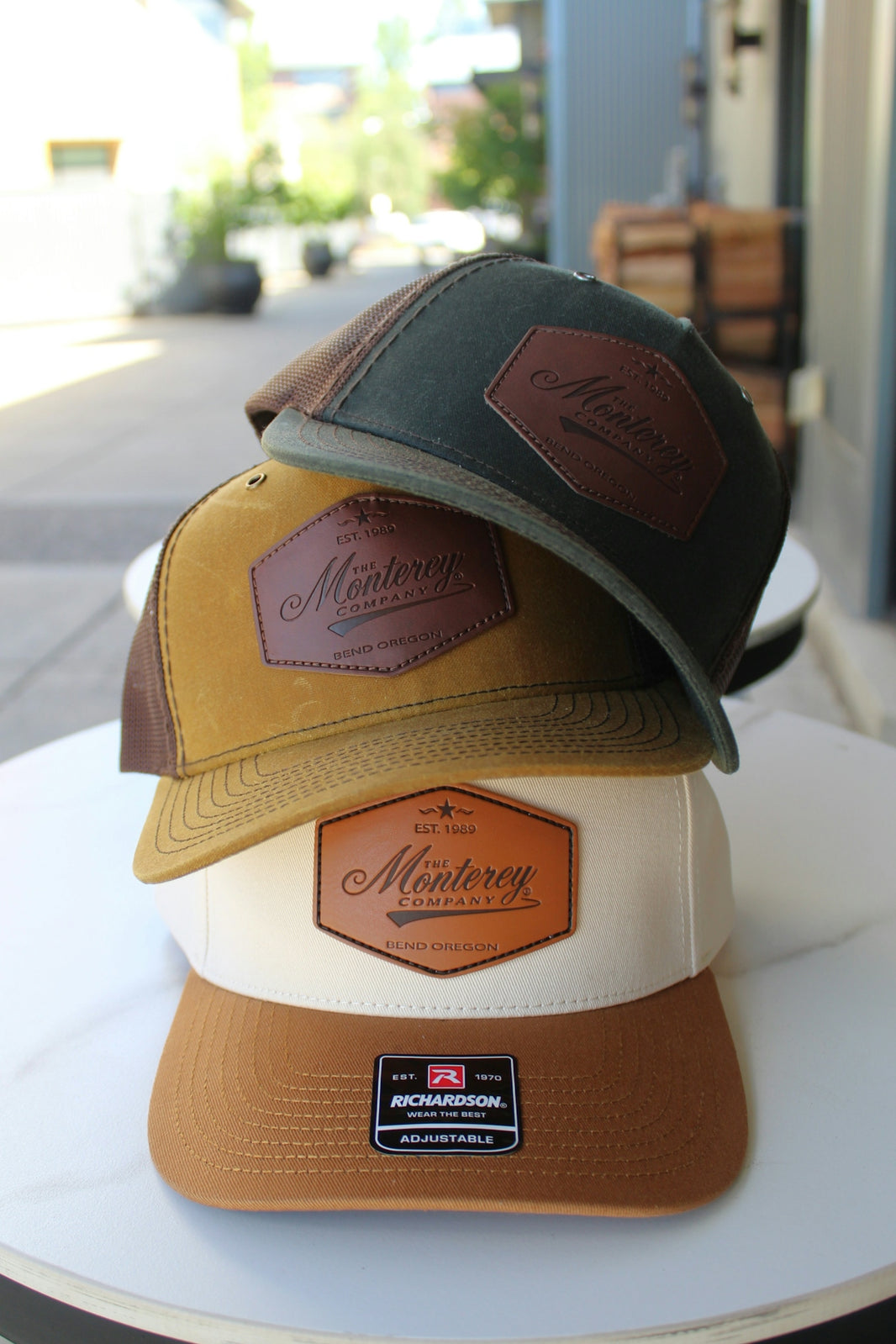 Three hats with monterey logos are stacked.