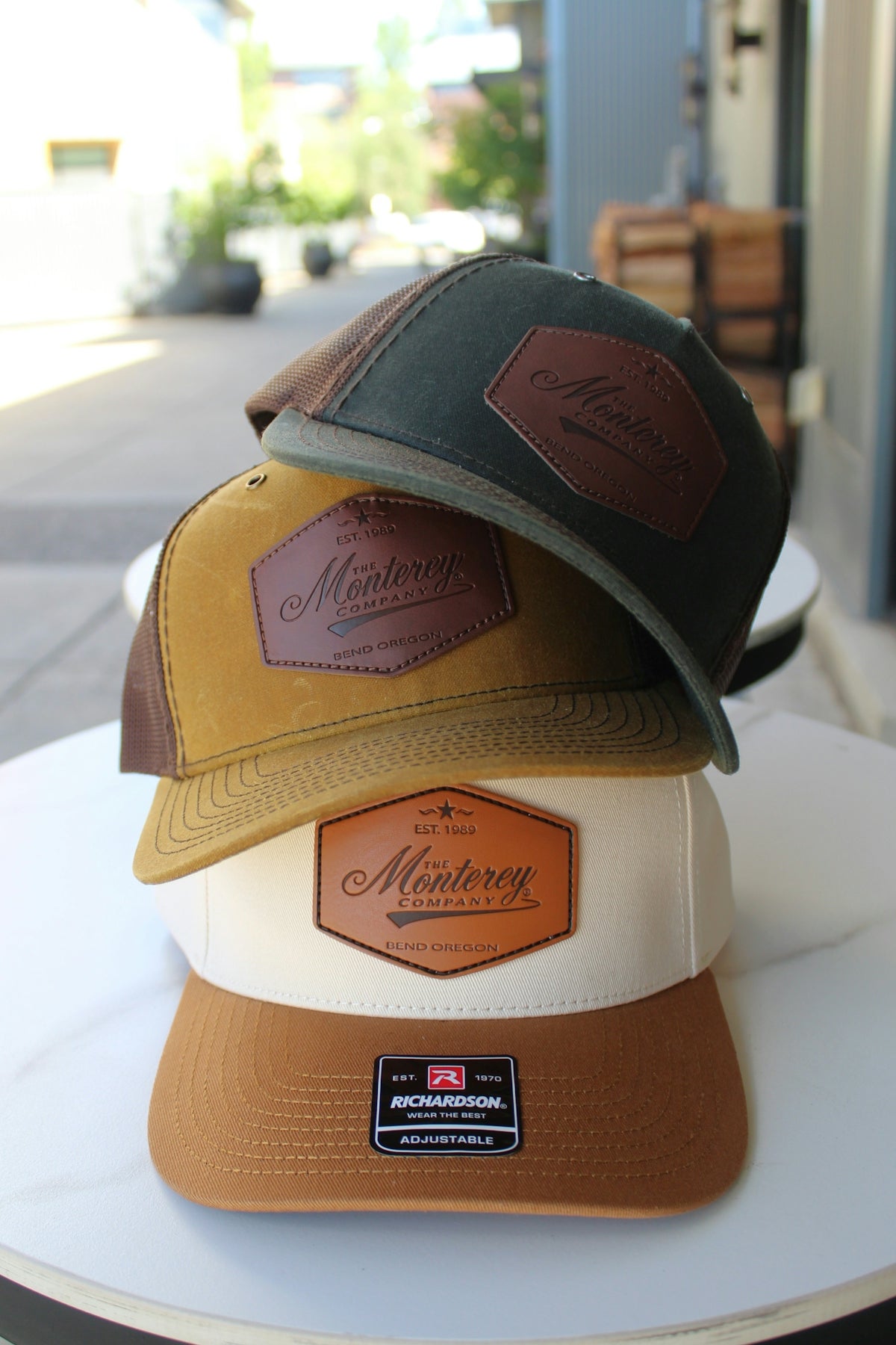 Three hats with monterey logos are stacked.