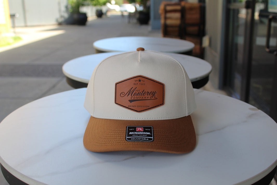 A hat with a leather patch sits on a table.
