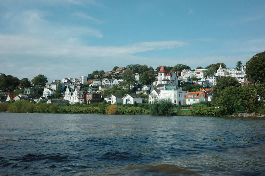 Waterfront view of a town on a hill.