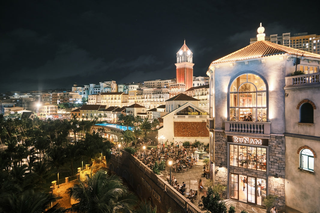 Illuminated buildings and palm trees at night
