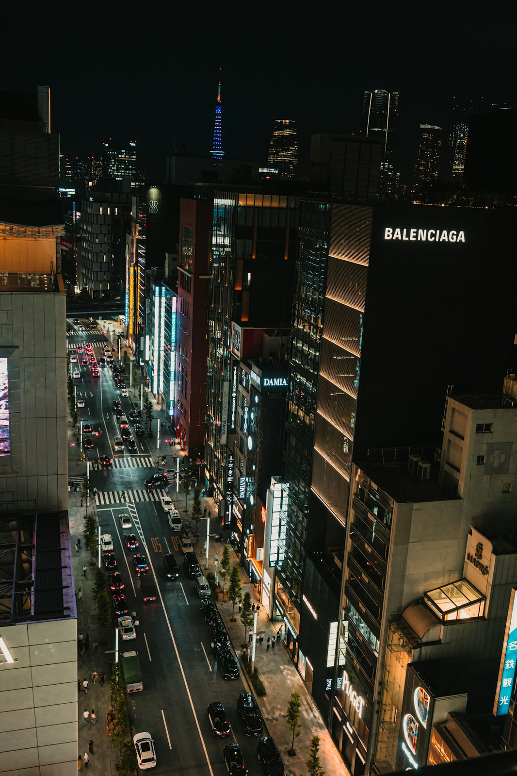 Vibrant cityscape with illuminated buildings and traffic at night.