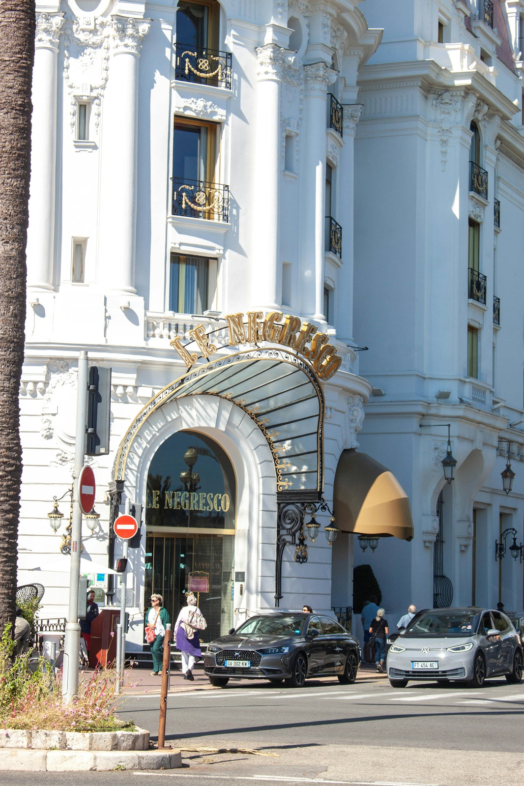 Elegant white building with cars on street.