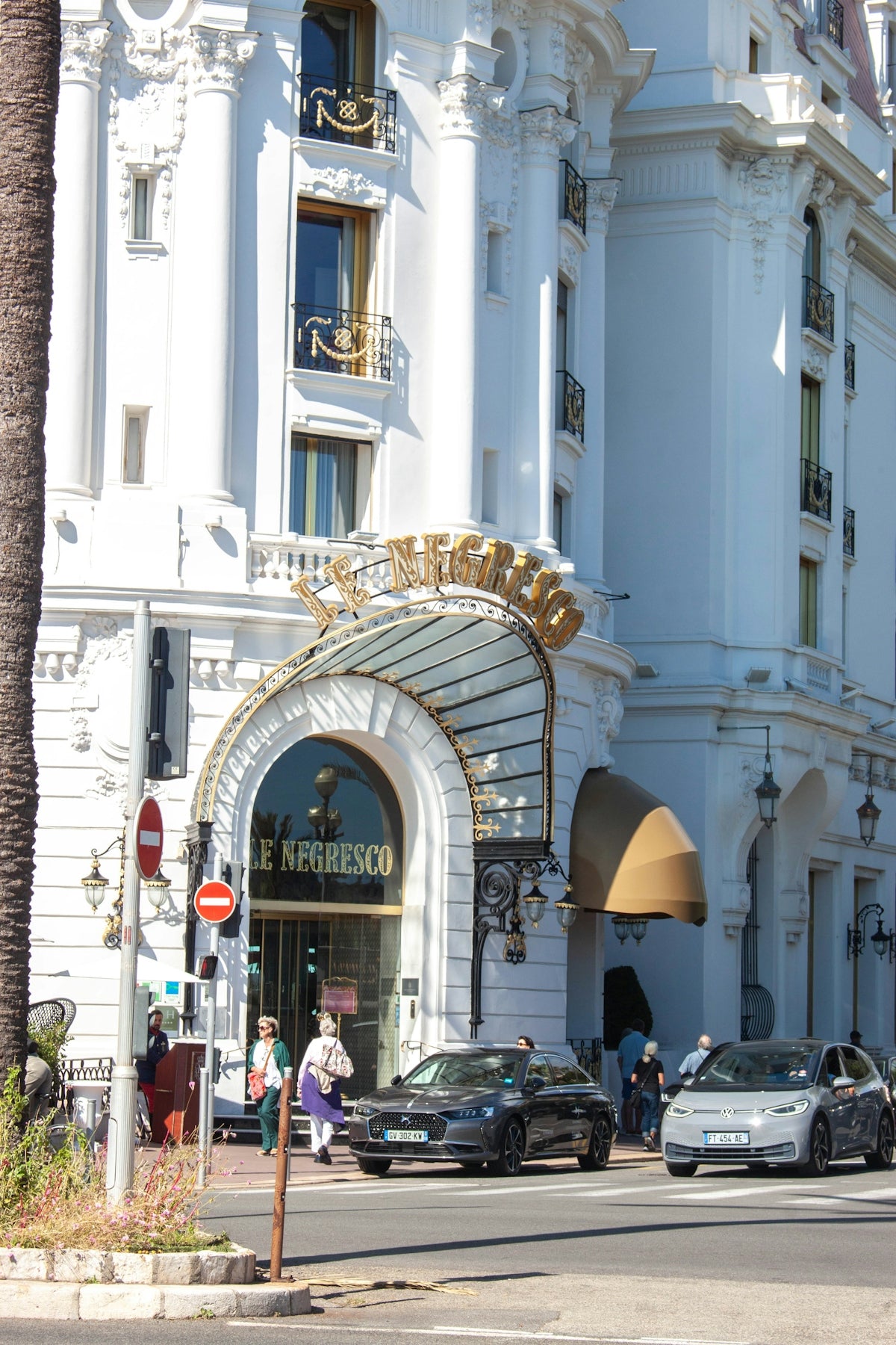 Elegant white building with cars on street.