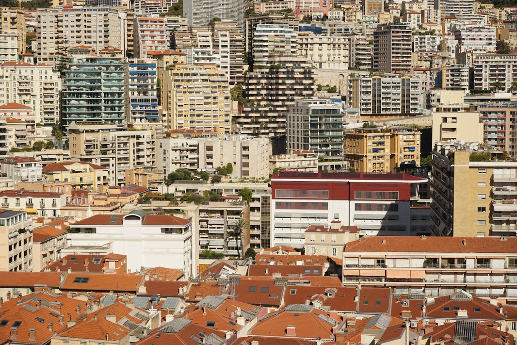 Dense city buildings with terracotta roofs below.