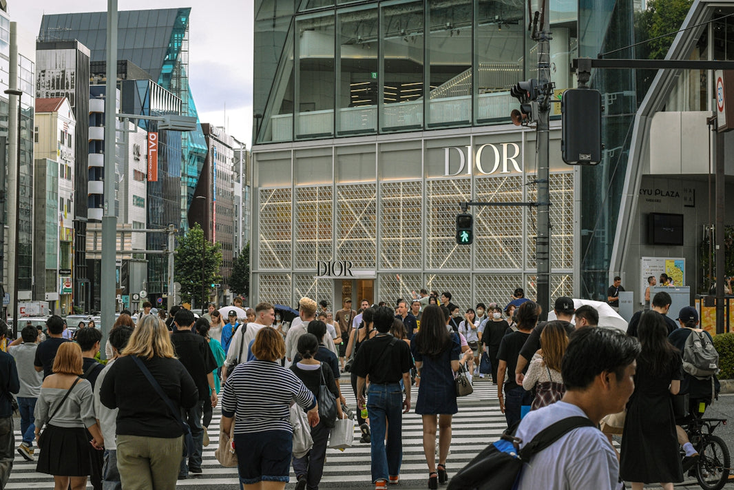 People crossing street in front of dior store