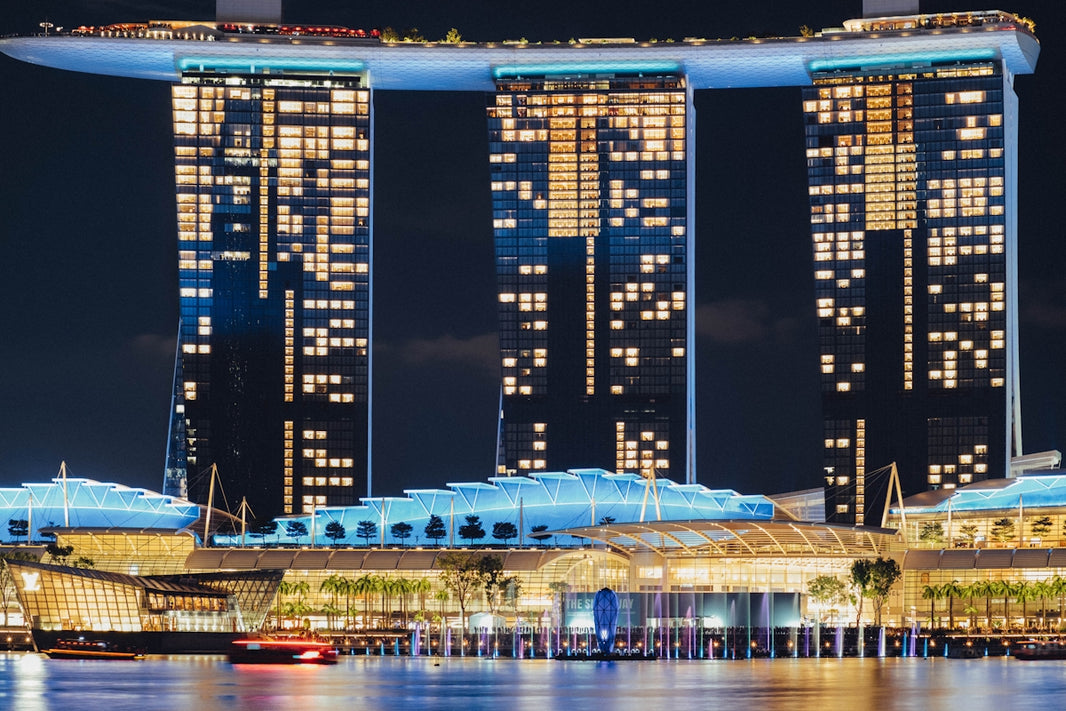 Modern illuminated skyscrapers at night with water reflection