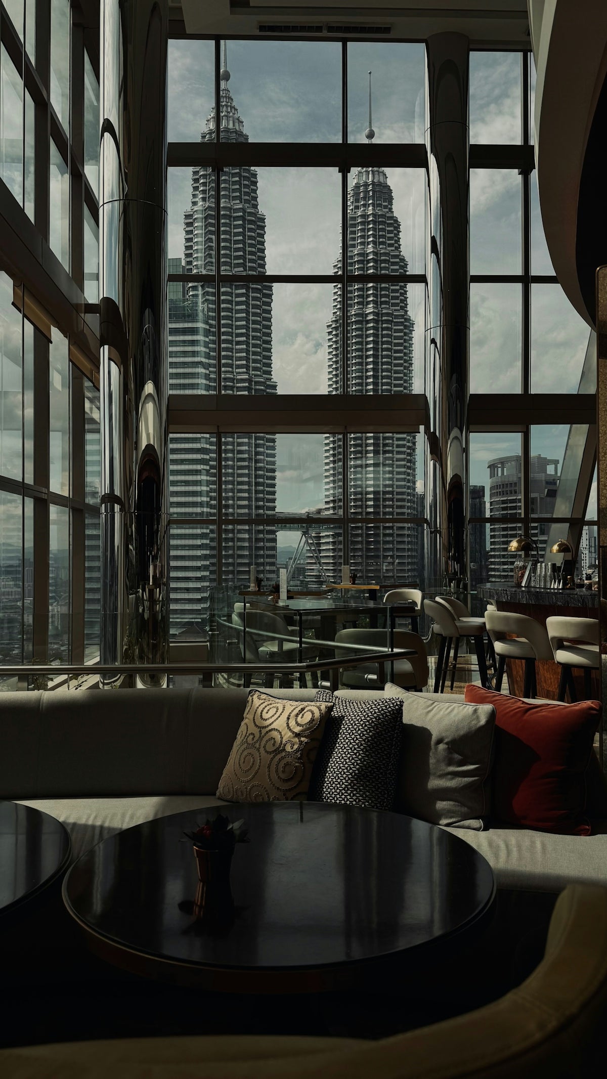 Petronas towers seen from a modern lounge interior.