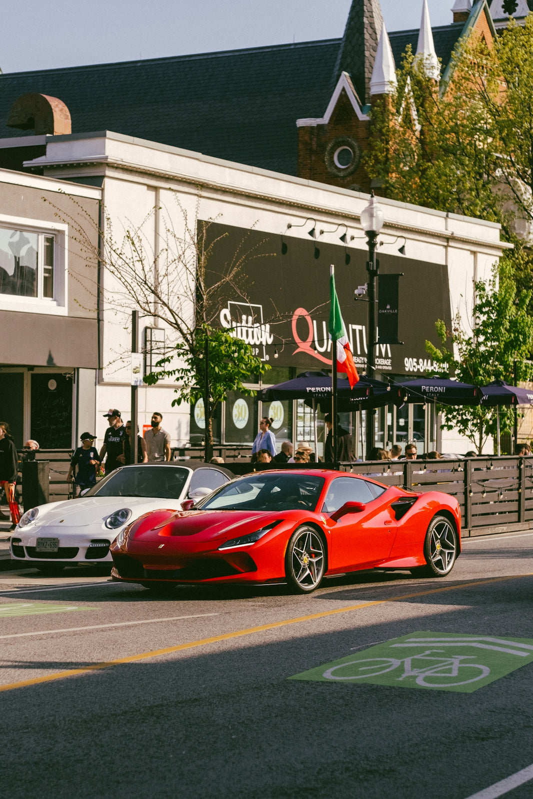 Red sports car parked on street with building background
