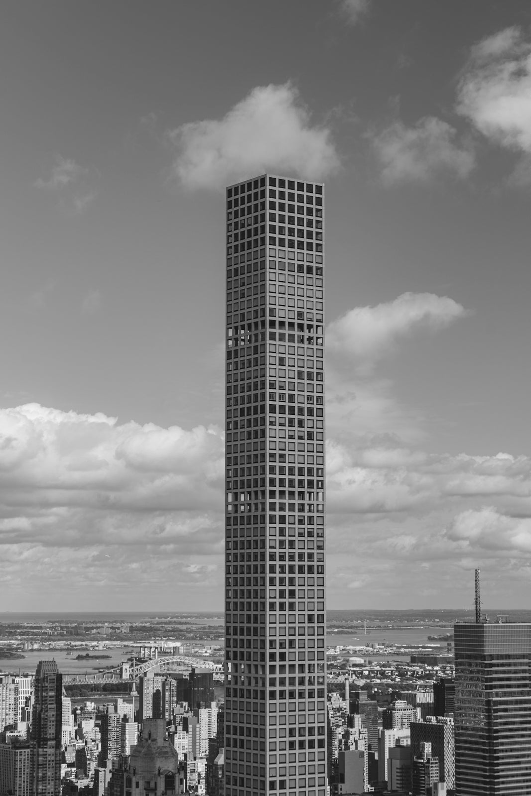 Tall skyscraper stands against a cloudy sky.