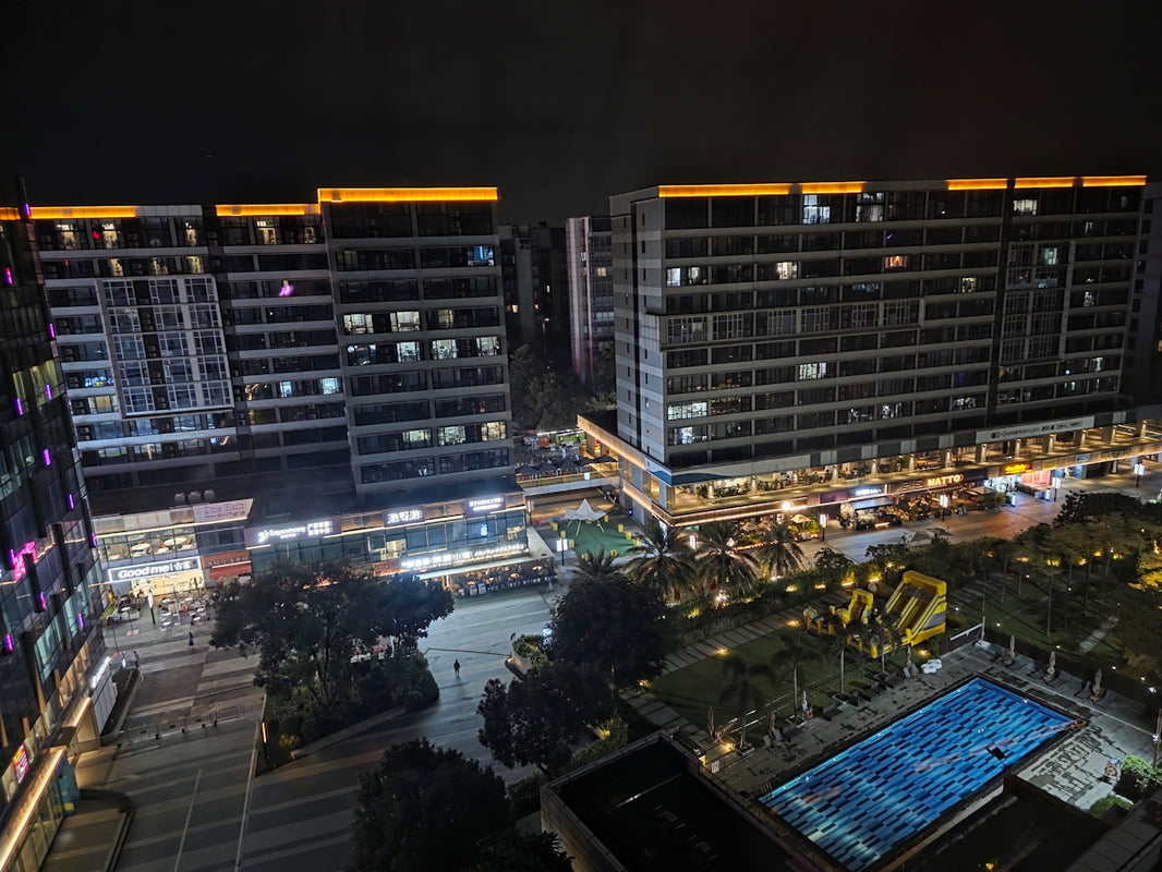 Modern buildings illuminated at night with city lights.