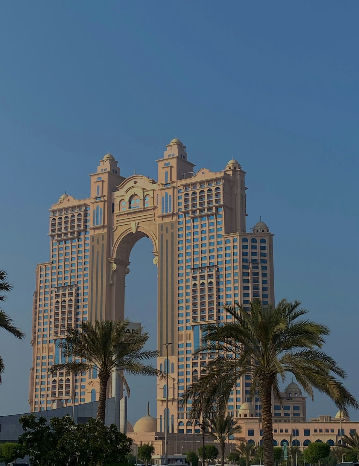 Modern hotel with archway and palm trees